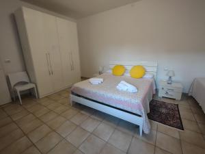 a bedroom with a bed with two yellow pillows on it at Agli Ulivi in Filo