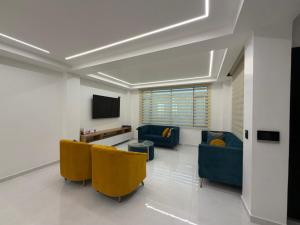 a living room with two blue couches and a tv at DLiam Home in Baños