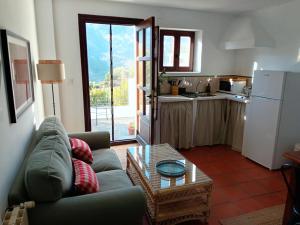 a living room with a couch and a table and a kitchen at La Locana in Bubión