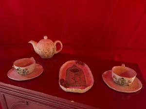 a table with two tea cups and a teapot at Glamping Izerska Bajka in Mirsk