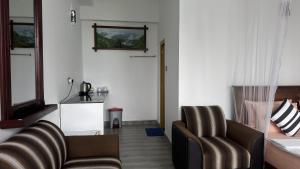 a living room with two chairs and a couch at Ever Green Mount in Ella