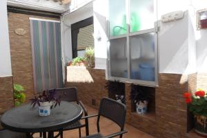 a patio with a table and chairs and a window at El patio de Marcos in La Recueja