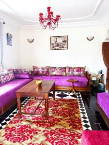 a living room with a purple couch and a table at Palm beach in Mansouria in Ben Slimane