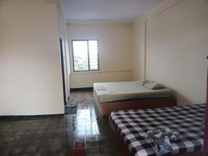 ein Schlafzimmer mit zwei Betten und einem Fenster in der Unterkunft Hotel Brawijaya in Timuran