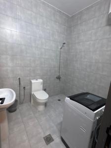 ein weißes Badezimmer mit Toilette und Waschbecken in der Unterkunft شقق نسائم ورد in Ta'if + 11 Fotos