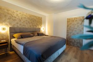 a bedroom with a large bed with a large headboard at Boutique Apartments Daniela in Faak am See