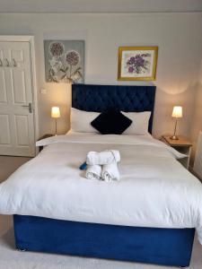 a bedroom with a bed with two towels on it at Grange House Budget Rooms in Leeds