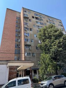a tall building with cars parked in front of it at Danuvia Studio 2 in Drobeta-Turnu Severin
