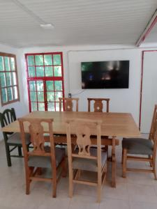 a dining room with a wooden table and chairs at La casita de Gorrión in Villa Ventana