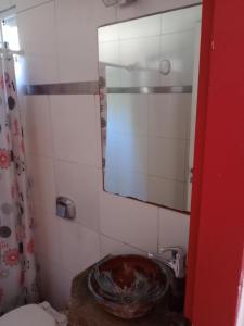 a bathroom with a sink and a mirror at La casita de Gorrión in Villa Ventana +3 photos