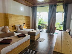 a hotel room with two beds and a balcony at Ever Green Mount in Ella