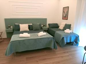a bedroom with two beds with towels on them at Umbrella Street Home in Catania +39 photos