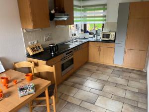 a kitchen with wooden cabinets and a table with a table at Ferienhaus Miriquidi Perle in Marienberg