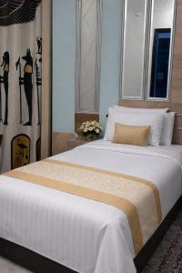 a bedroom with a large bed with white sheets at Casa Latina pyramids view in Cairo