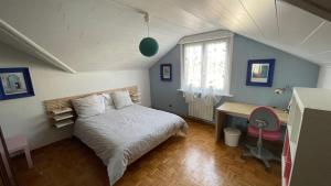 a bedroom with a bed and a desk and a window at Appartement entier, calme, confortable et spacieux in Gundershoffen