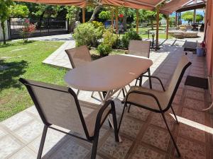 a wooden table and chairs on a patio at Coral Bungalow in Rákhai
