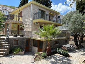a house with a palm tree in front of it at Boka Hub Apartments in Krašići