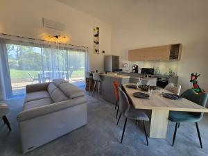 eine Küche und ein Wohnzimmer mit Sofa und Tisch in der Unterkunft Chicken Fields Good ! in Auch
