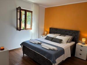 a bedroom with a large bed with two towels on it at Boka Hub Apartments in Krašići