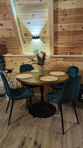 a dining room with a table and green chairs at Villa Tara in Žabljak