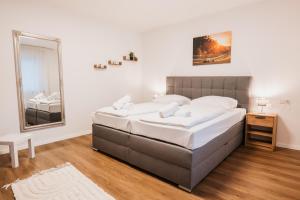 a bedroom with a large bed and a mirror at Waldblick am Ring in Kelberg