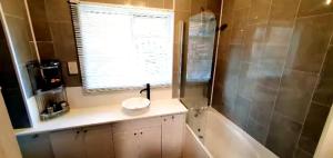 a bathroom with a tub and a sink and a window at Reigate - 1 Bed by Mobius Property Solutions in Reigate