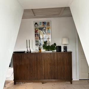 a wooden dresser in a living room with a wall at Strandvænge 12, 4600 Køge in Køge