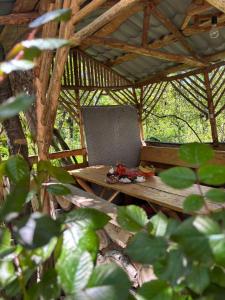 a wooden table in a straw hut in the woods at Lucy Guest House in Garni