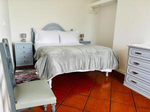 a bedroom with a bed and a chair and a dresser at Biscoitos Top View in Biscoitos +23 photos