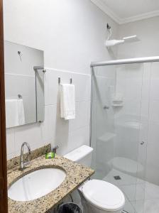 a bathroom with a sink and a toilet and a shower at BURITI HOTEL Barra do Riacho Aracruz in Aracruz +25 photos