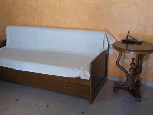 a bed with a wooden frame and a side table at Coral Bungalow in Rákhai +3 photos