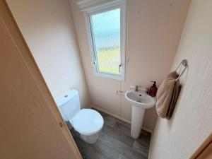a small bathroom with a toilet and a sink at Magnolia in Porthcawl +1 photo