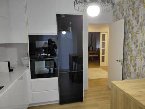 a kitchen with white cabinets and a black refrigerator at A casa de Aliciña in Sanxenxo