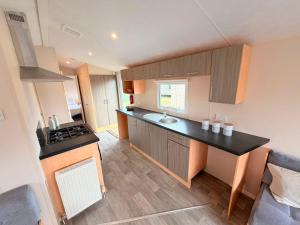 a kitchen with a sink and a counter top at Magnolia in Porthcawl