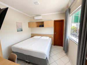 a small bedroom with a bed and a window at BURITI HOTEL Barra do Riacho Aracruz in Aracruz