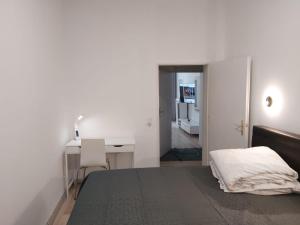 a white bedroom with a bed and a desk at HOME Prime Stay Chemnitz in Chemnitz