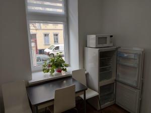 a kitchen with a table and a refrigerator and a window at HOME Prime Stay Chemnitz in Chemnitz