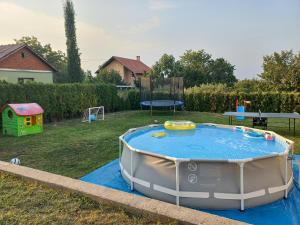 a small pool in a yard with a playground at Vila Pogled in Novi Sad