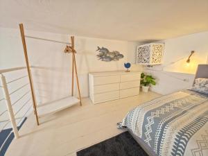 a bedroom with a bed and a dresser at La Perla Blu in Calasetta