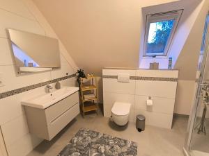a bathroom with a sink and a toilet and a window at Ferienwohnung Heide in Walsrode +17 photos