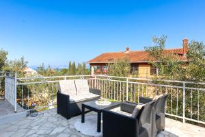 a patio with a table and chairs on a balcony at Kuća Lucija in Supetar