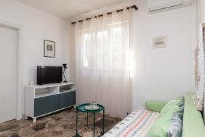a living room with a couch and a tv at Kuća Lucija in Supetar