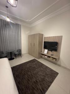 ein Hotelzimmer mit Fernseher und Wohnzimmer in der Unterkunft شقق نسائم ورد in Ta'if