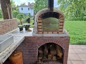an outdoor brick oven with a pile of wood at La Granjita del río in Nava de Ordunte +25 photos