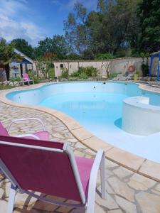 a large swimming pool with a chair and a chair at Chalet confort in Saint-Rémy