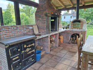 an outdoor kitchen with a brick oven and a table at La Granjita del río in Nava de Ordunte