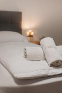 two rolled towels sitting on top of a bed at Waldblick am Ring in Kelberg