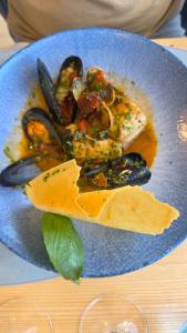 a blue plate of food with mussels and other foods at La Perla Blu in Calasetta +26 photos