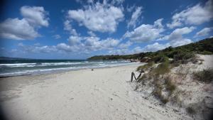 a beach with a person standing on the sand at La Perla Blu in Calasetta