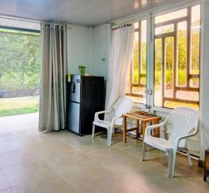 a kitchen with two chairs and a table and a refrigerator at Suite campestre a 5 minutos del parque con aire acondicionado in Acacías